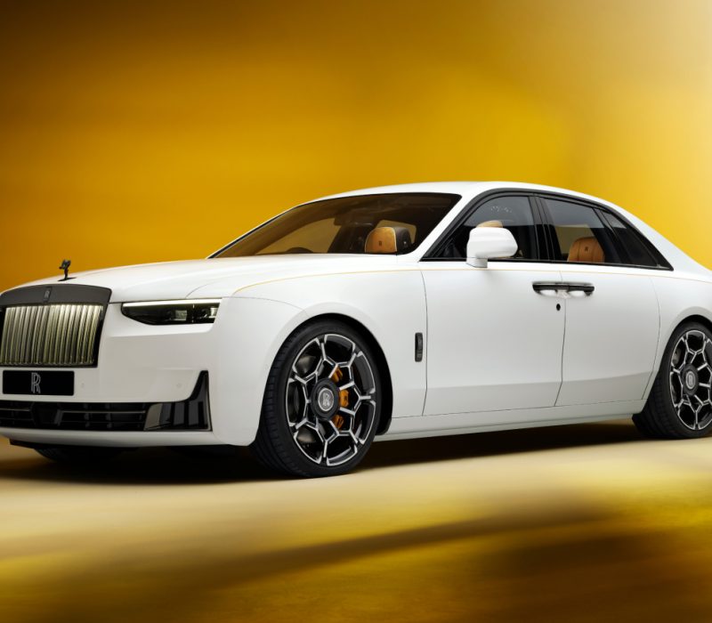 Side angled shot of the white Black Badge GSII showcasing the whole car in horizontal view. Yellow and black background.